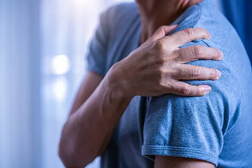 man holding painful shoulder
